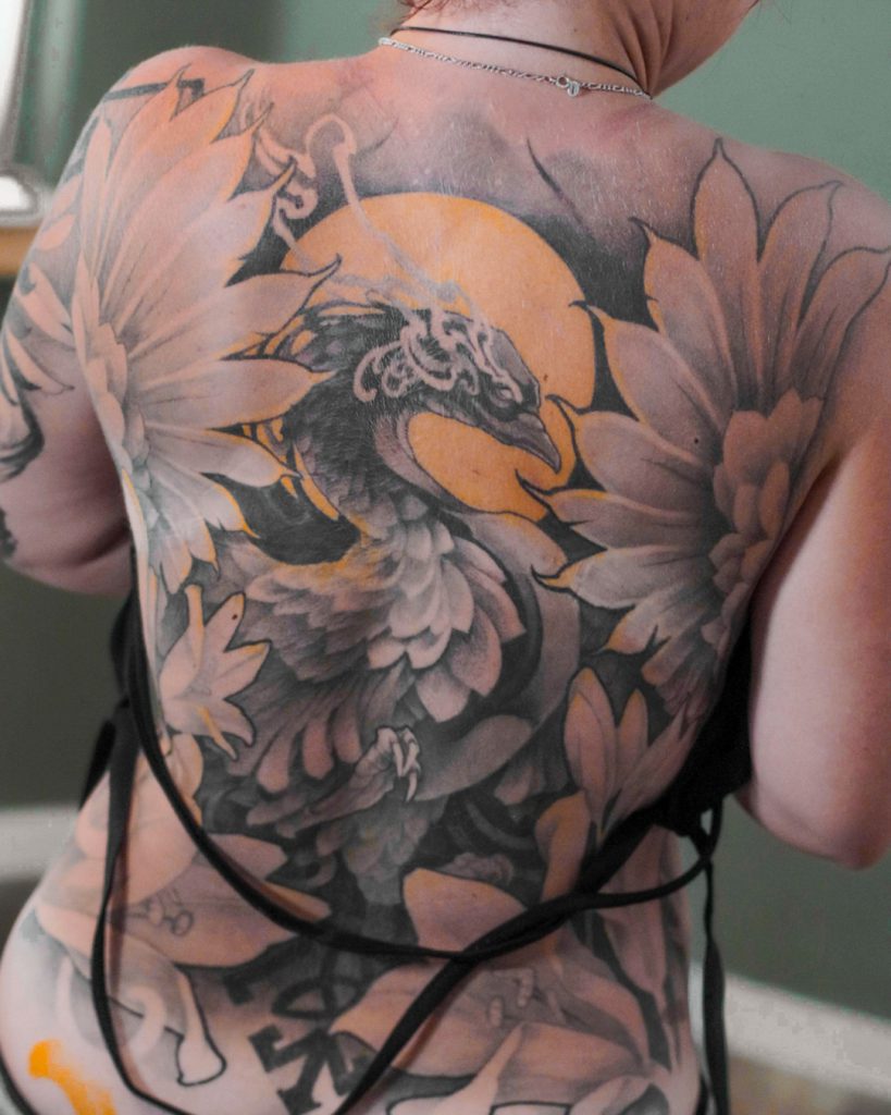 Tatouage de dos completd d'un phoenix dans un style néotrad par le tatoueur Genevois Bryan Ly