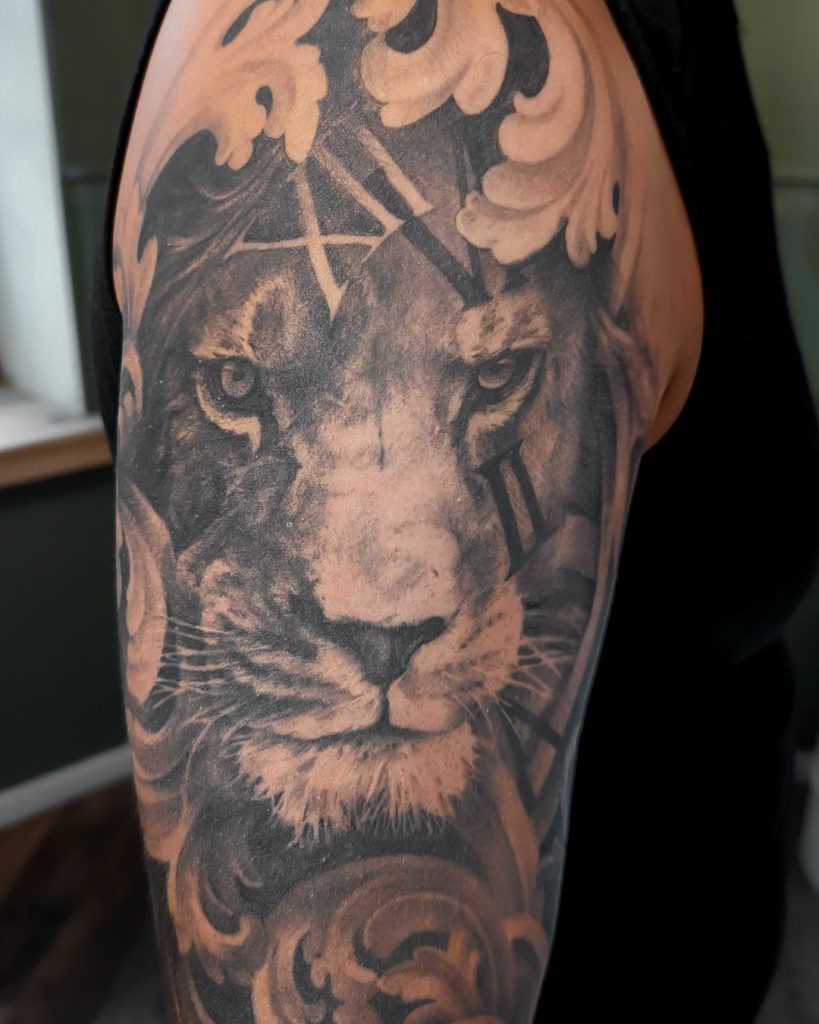 Tatouage de lion sur un haut de bras par Bryan Ly à Genève
